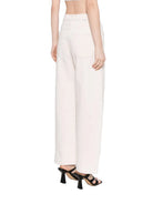 Person wearing white pants on a plain background