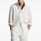 Person in a white workshirt with a blue scarf on a white background