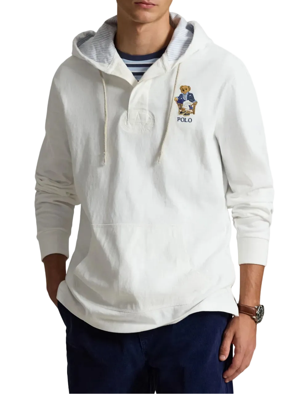 Person in a white hoodie with an embroidered bear logo on the chest.