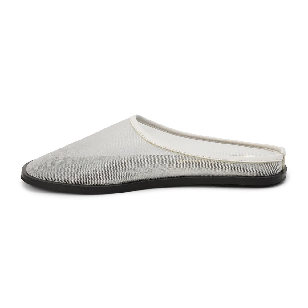 White mesh mule with a flat black sole on a white background 