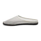 White mesh mule with a flat black sole on a white background 