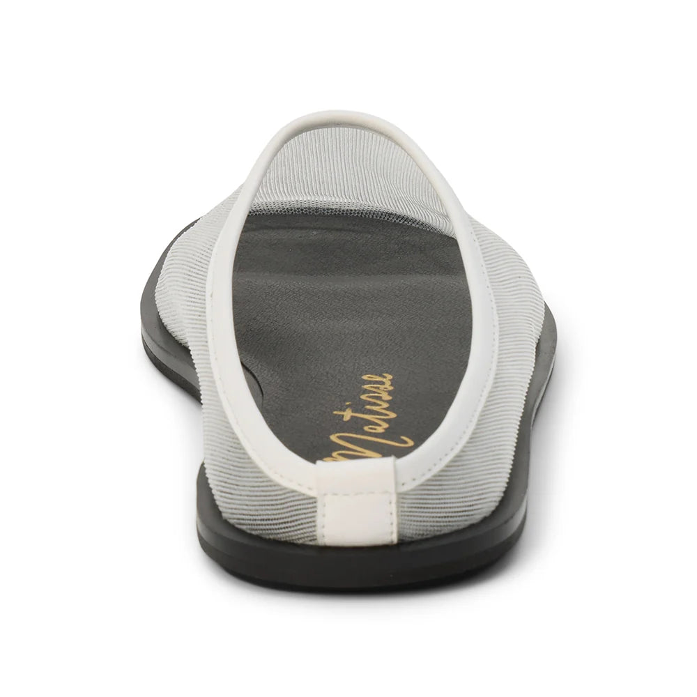 Back view of a white mesh mule with a flat black sole on a white background 