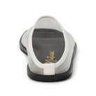 Back view of a white mesh mule with a flat black sole on a white background 