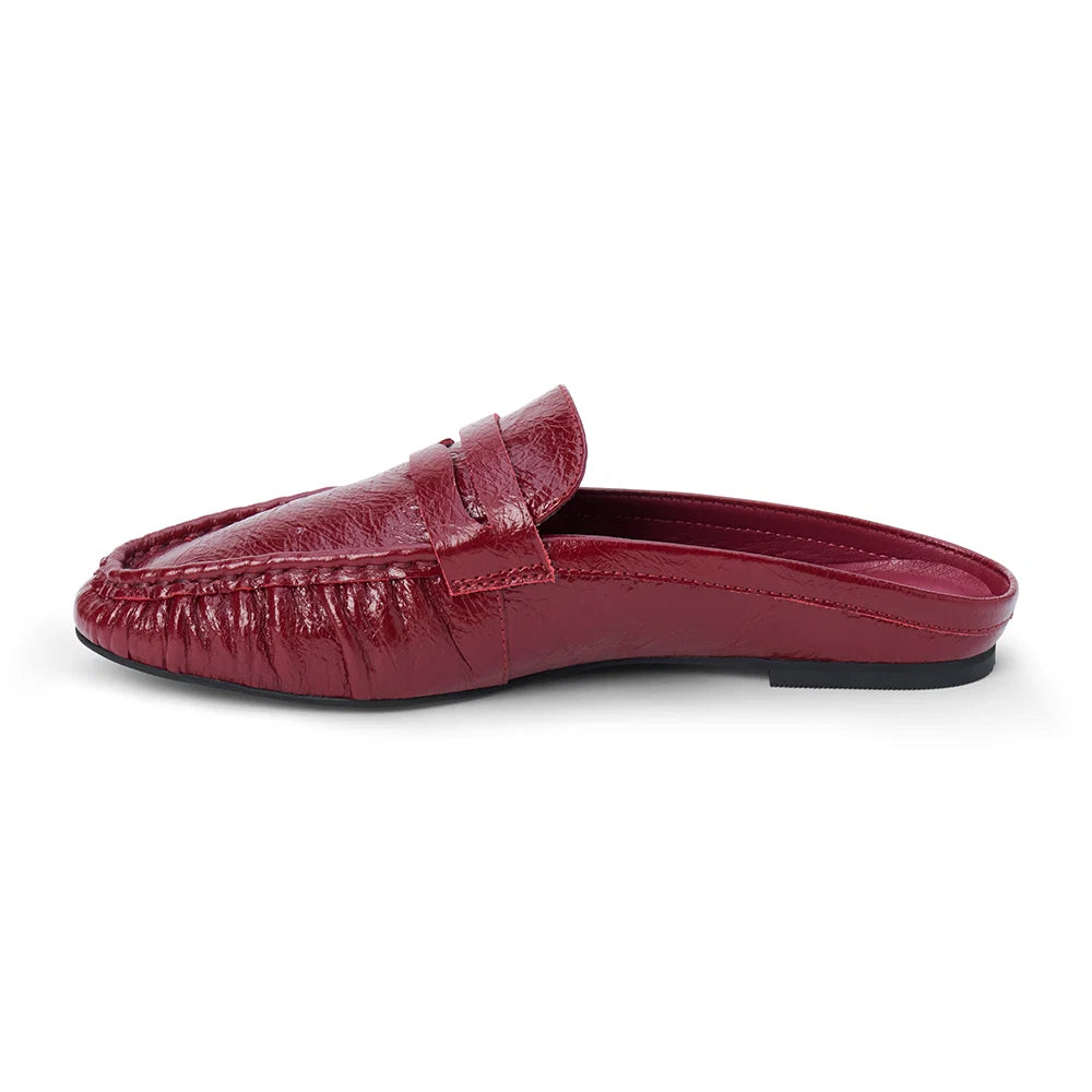 Side view of a glossy red leather penny loafer mule on a plain white background.
