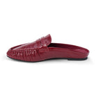Side view of a glossy red leather penny loafer mule on a plain white background.