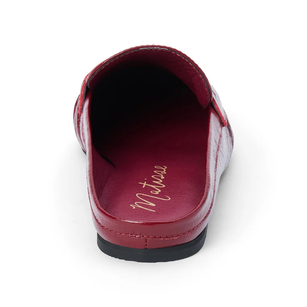 Back view of a glossy red leather penny loafer mule on a plain white background.