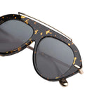 Dark marble framed sunglasses with black lenses and gold accents on a white background 