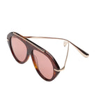 Tortoise sunglasses with red lenses and gold detailing on a white background