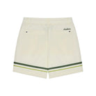 Off-white shorts with a green and yellow stripe detail at the hem, featuring a small embroidered 'Maison' logo on the upper right side, shown against a plain white background.