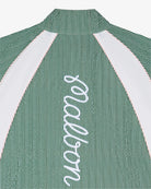 Close-up of the back of a green seersucker pullover jacket with a 'Malbon' logo down the back on a white background