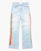 Light wash blue denim jeans with vibrant red, orange, and yellow flame-like printed vertical patterns running down both outer legs, shown flat against a plain white background.