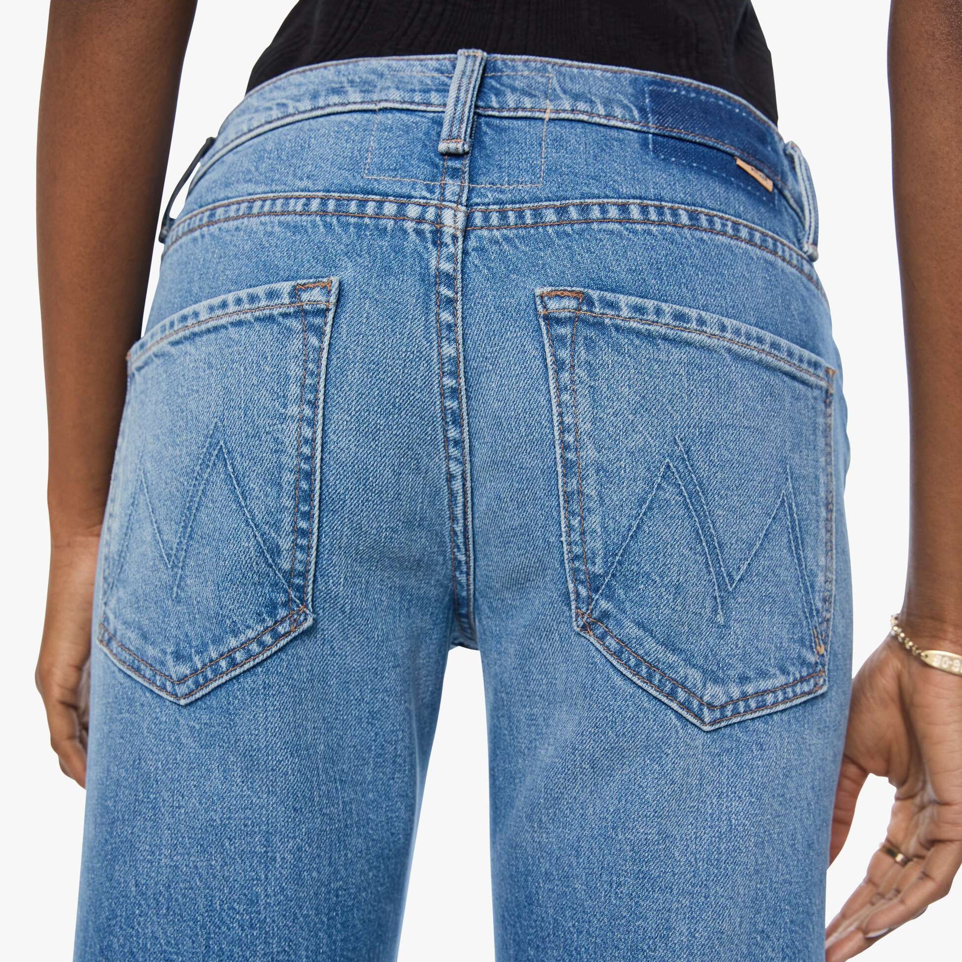 Blue jeans with a brand logo on the back pocket against a white background