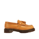 A single tan leather loafer with a tassel strap and a dark brown sole, shown in profile against a white background.