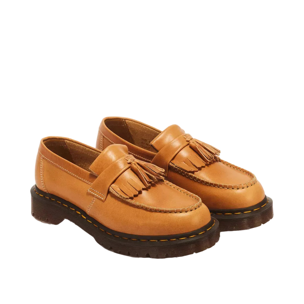A pair of tan leather tassel loafers with dark brown soles, photographed on a clean, white background.