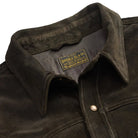 Close-up of a vintage black suede jacket with a brand label on the collar.