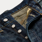 Close-up of a blue denim jeans with buttons and a worn-in look.