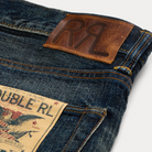 Close-up of blue jeans with a brown leather label and brand tag.