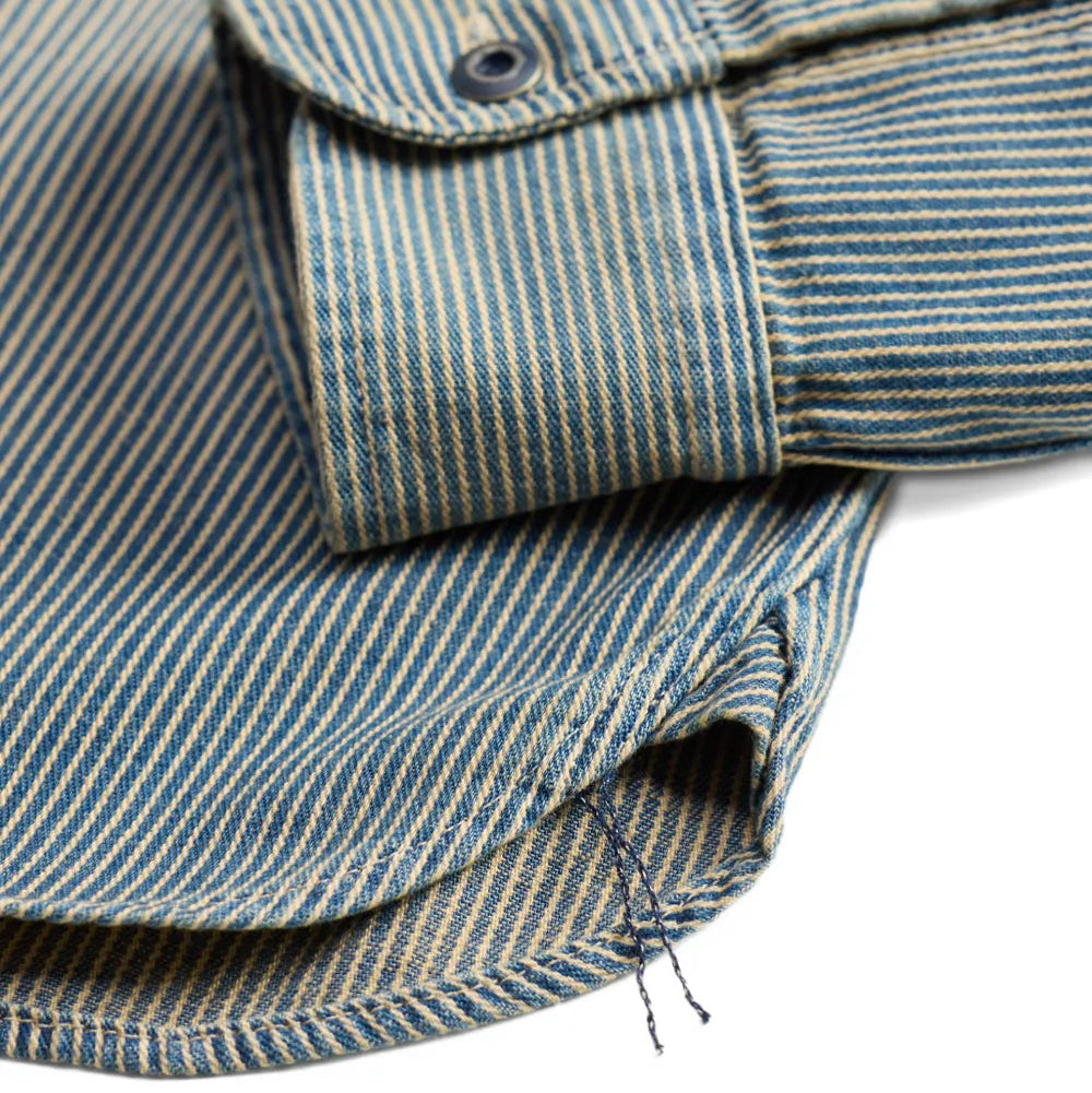Close-up of a striped fabric garment, showing a folded cuff with a button and a hem detail on a white background.