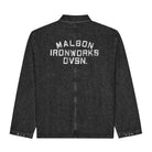 A dark black ribbed denim jacket shown from the back, featuring 'MALBON IRONWORKS DVSN.' printed in distressed white block letters across the upper back.