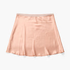 A peach-colored silk mini skirt with a matching elastic waistband, laid flat against a clean white background.
