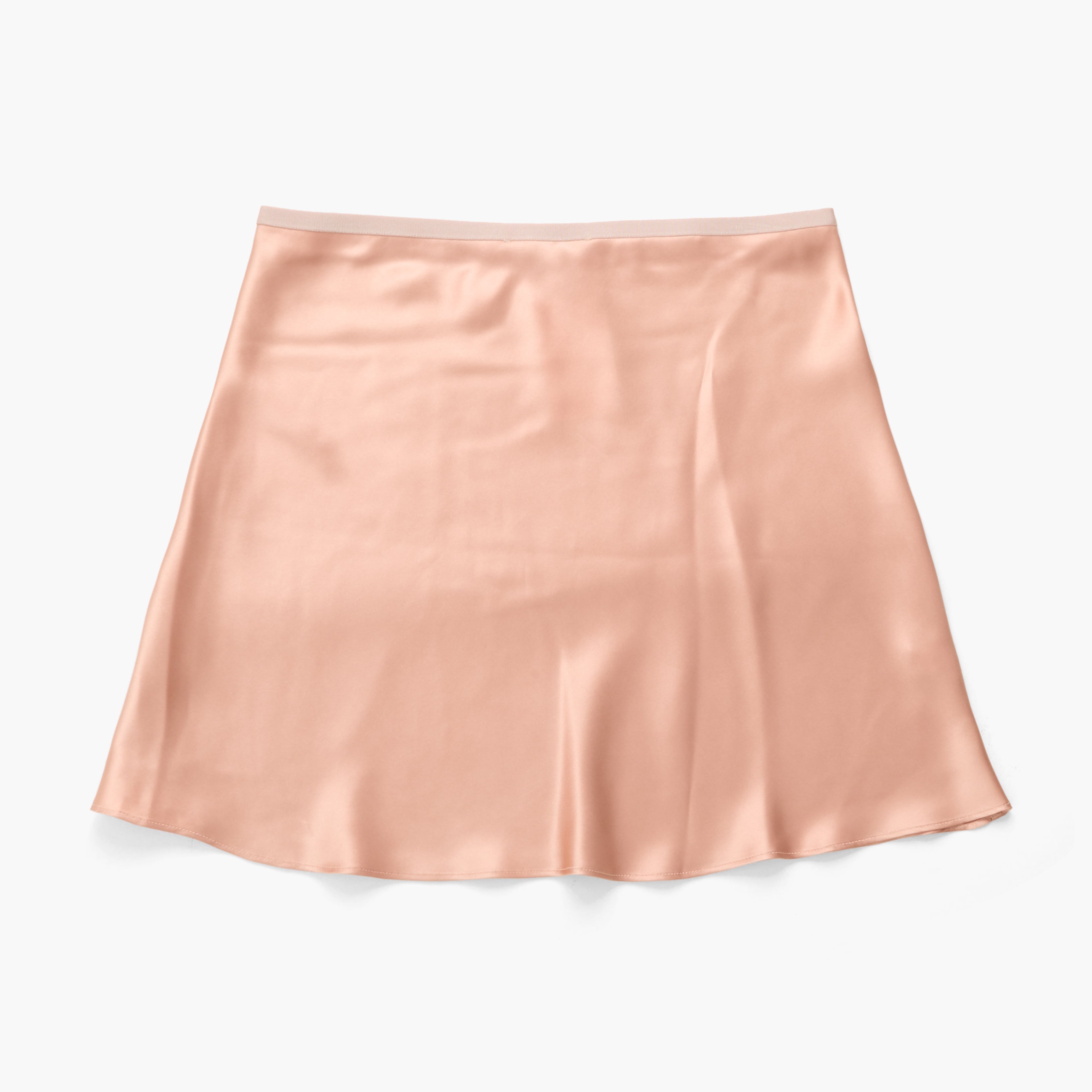 A peach-colored silk A-line mini skirt with a subtle sheen, laid flat against a clean white background.