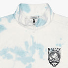 A close-up of a white and light blue tie-dye quarter-zip pullover jacket. The left chest features a black printed graphic of a Grateful Dead skull inside a circle with the word 'MALBON' above it.