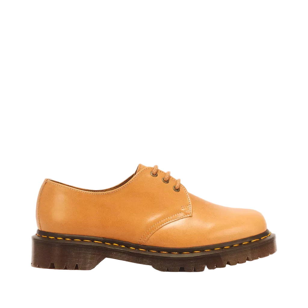 A single tan leather lace-up shoe with a dark brown sole, shown in a side profile against a white background.