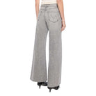 Woman wearing gray wide-leg pants and a white top on a white background