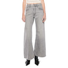 Woman wearing a white top and gray flared jeans on a white background