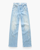 Light blue denim jeans with white and gold rhinestone floral embellishments running down the front of each leg, shown flat against a white background.