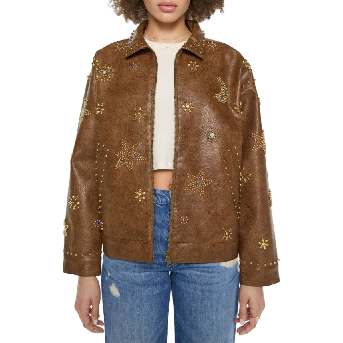 A model wearing a brown faux-leather jacket embellished with gold star and crescent moon studs, styled with a cream crop top and blue jeans against a plain white background.