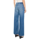 Woman wearing blue jeans and a white top on a white background
