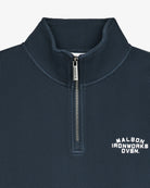 Close-up of a navy blue textured quarter-zip pullover with a white embroidered 'MALBOX IRONWORKS DVSN.' logo on the left chest and a silver zipper pull.