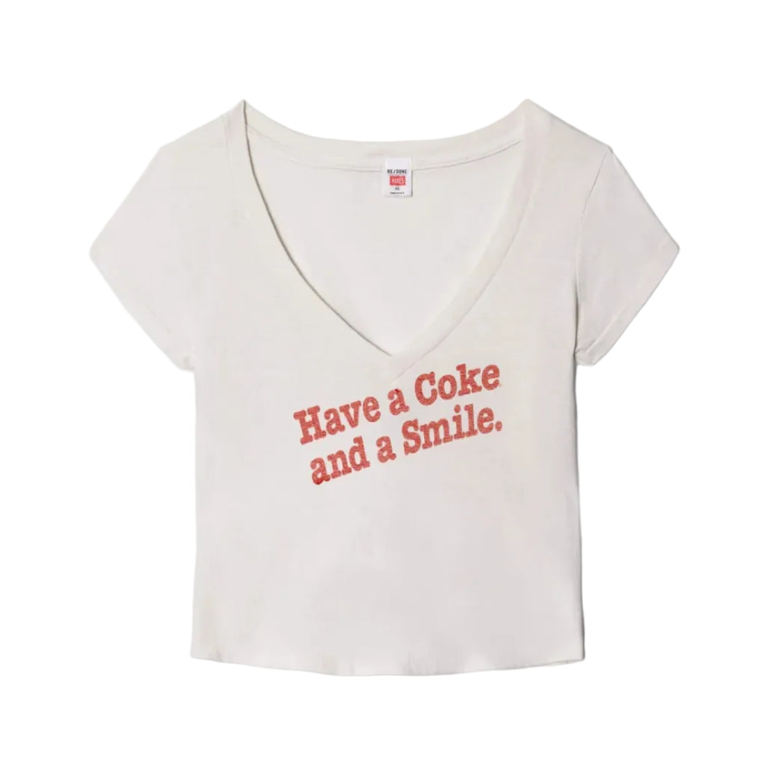 Vintage white v-neck t-shirt with "Have a Coke and a Smile." printed on the front laid flat on a white background