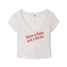 Vintage white v-neck t-shirt with "Have a Coke and a Smile." printed on the front laid flat on a white background