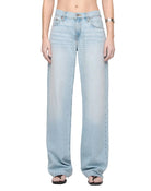 Model wearing light blue wash denim jeans by RE/DONE, low-rise straight-leg fit, styled with sandals, shown from waist down against a white background.