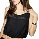 Model wearing the black Allegra Top by RE/DONE, a sleeveless cropped top with lace trim and button-front detail, shown from the shoulders down against a white background.