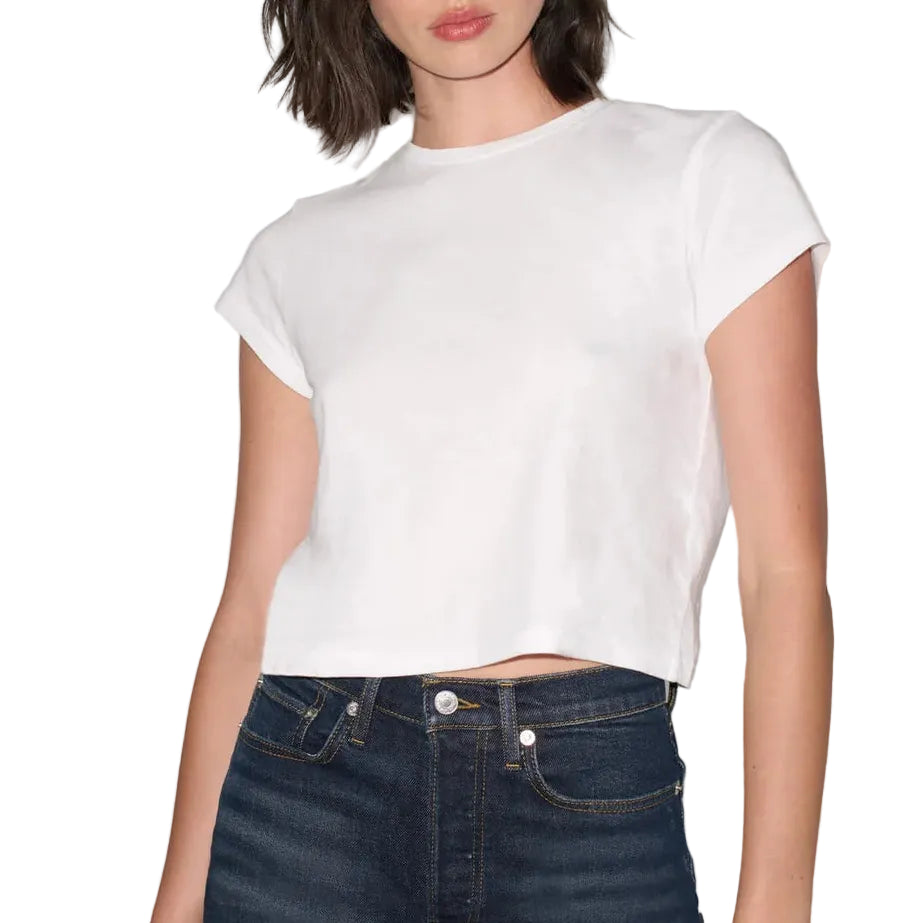 A woman modeling a white short-sleeve cropped t-shirt paired with dark blue jeans, set against a plain white background.