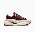 A low-top sneaker with a textured burgundy upper, white laces, and a chunky white platform sole with burgundy accents, shown from the side on a white background.