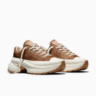 A pair of chunky low-top sneakers in brown and off-white, featuring a textured burgundy upper, white laces, and a thick white platform sole with burgundy outsole details, shown against a plain white background.