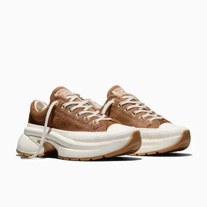 A pair of chunky low-top sneakers in brown and off-white, featuring a textured burgundy upper, white laces, and a thick white platform sole with burgundy outsole details, shown against a plain white background.