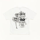 A white Stüssy t-shirt featuring a black graphic print on the back. The graphic includes the Stüssy logo, the words 'Los Angeles, California USA', dice, and a stylized illustration of a woman in a feathered hat.