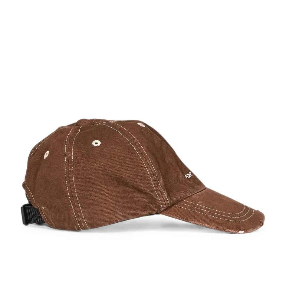 Side profile of the brown Logo Cap, showing the curved brim, contrast stitching and the black buckle strap at the back.