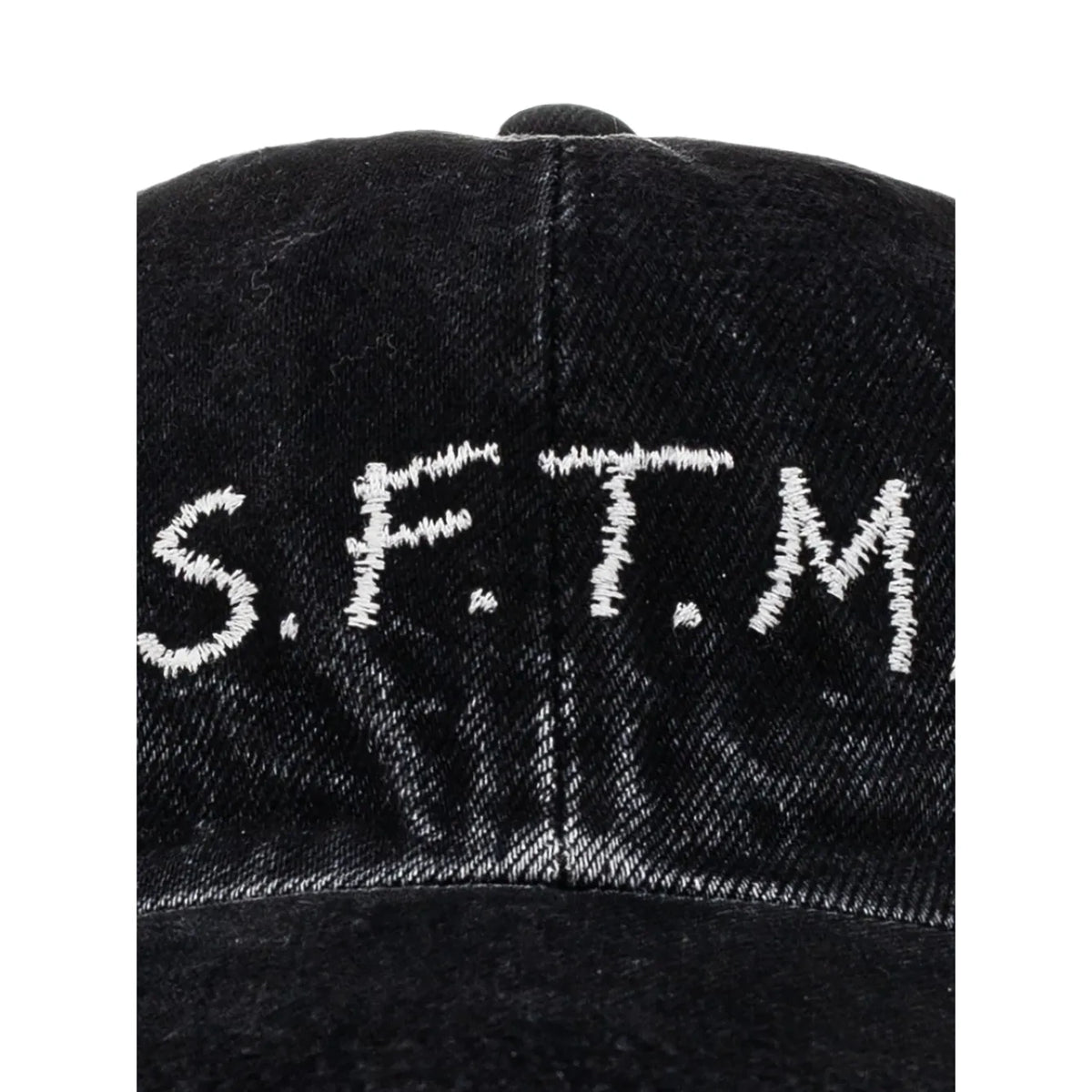 Close-up of the off-white “S.F.T.M.” embroidery on the front of the washed black denim cap.