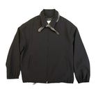 Front view of the Song For The Mute Slim Coach Jacket laid flat. A black zip-front jacket with a point collar, a gray neckerchief knotted at the neck, welt pockets and elastic cuffs.