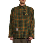 A model wears the School Shirt buttoned, showing the relaxed fit, the chest patches and a woven label patch at the lower front.