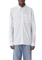 Person wearing a white shirt with black stripes and blue jeans on a white background