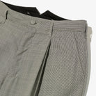 Close-up of gray checkered pants on a white background