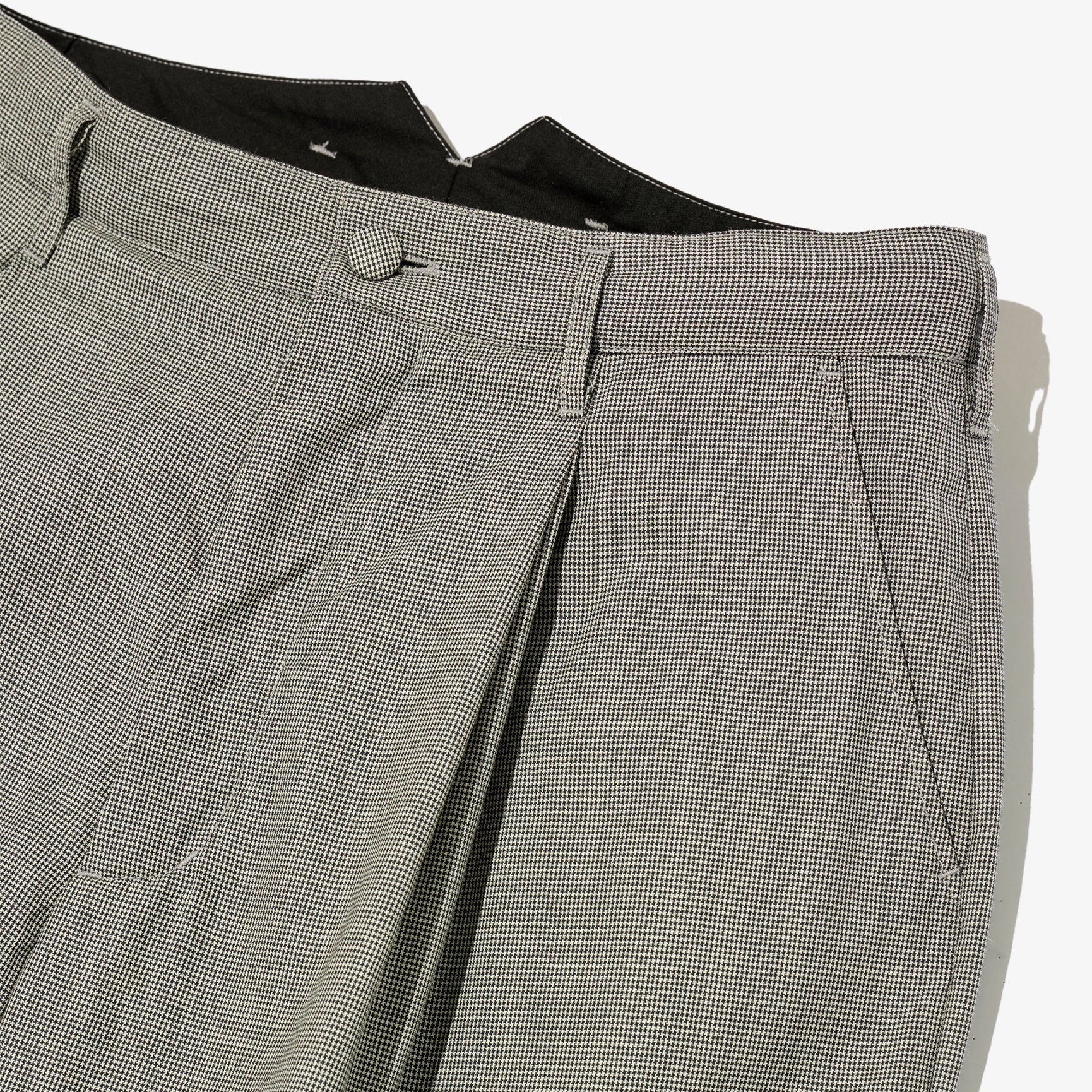 Close-up of gray checkered pants on a white background