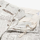 White pants close-up with newspaper print on a white background